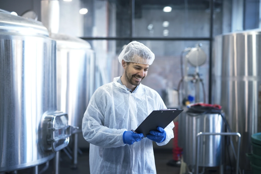industrial-worker-technologist-white-suit-with-hairnet-protective-gloves-looking-checklist-smiling