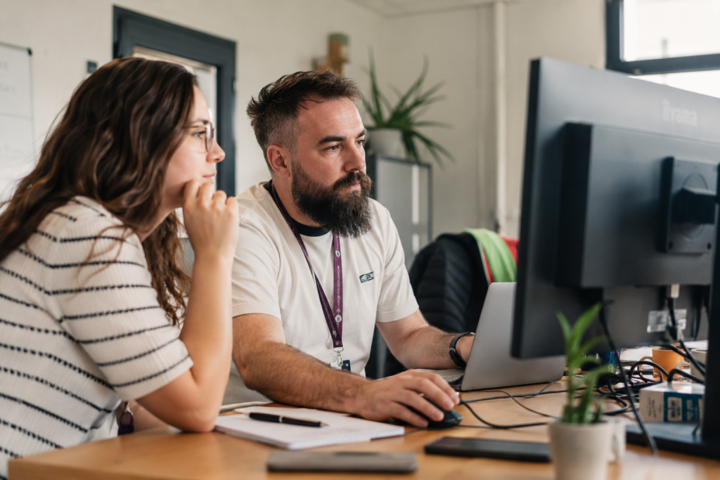 Deux collaborateurs travaillant sur un poste informatique pour structurer des usages et données partagés