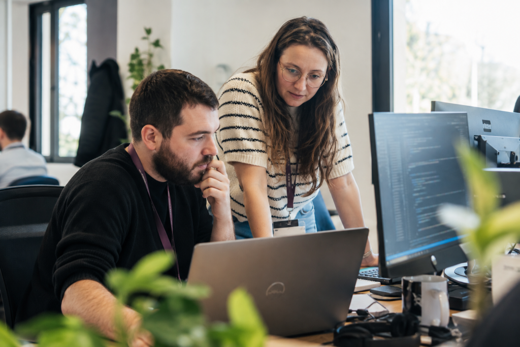 Deux collaborateurs analysant une application existante sur un poste de travail