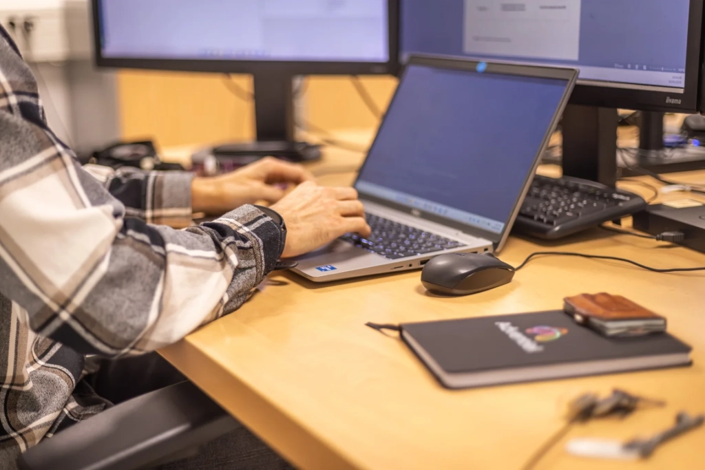 Technicien supervisant un système informatique depuis un poste de travail multi-écrans